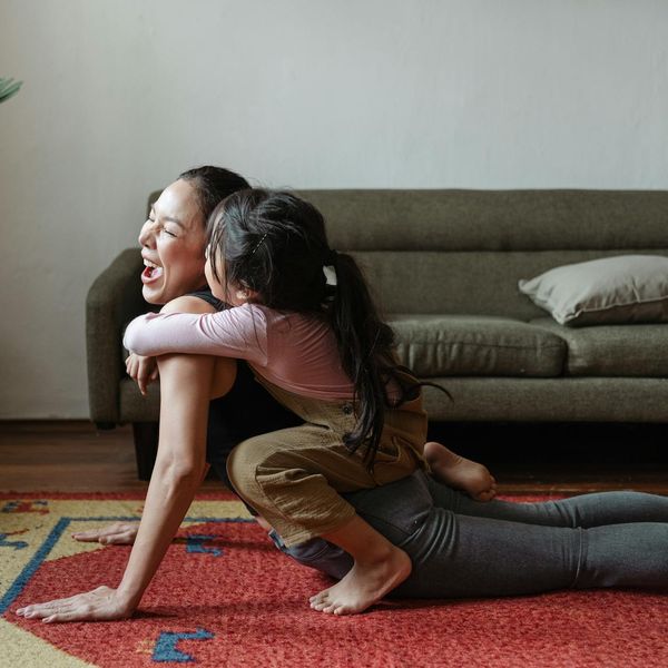Smiling woman in a relaxed yoga posture at home.